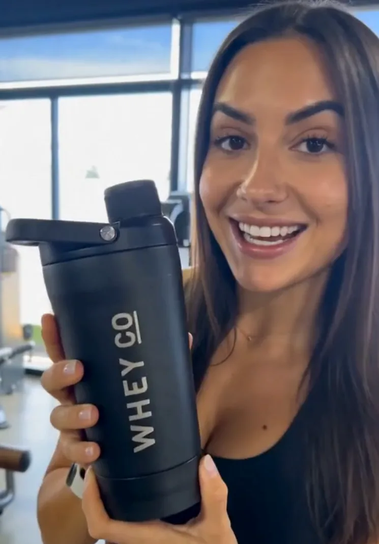 Customer holding a Whey Co shaker at the gym